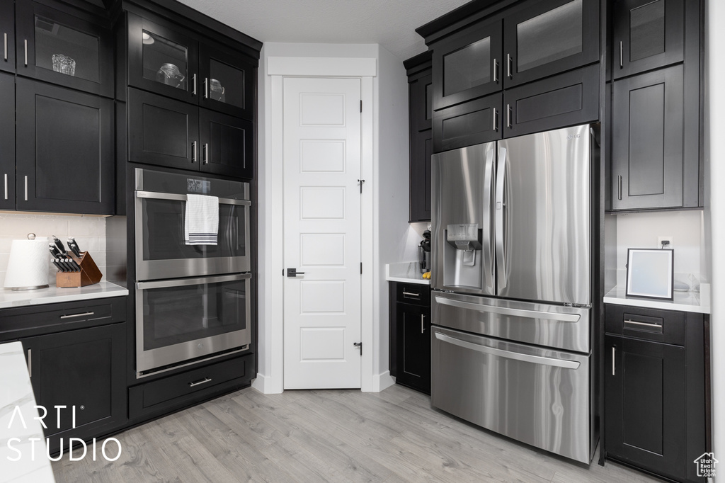 Kitchen featuring light hardwood / wood-style flooring, stainless steel appliances, and backsplash