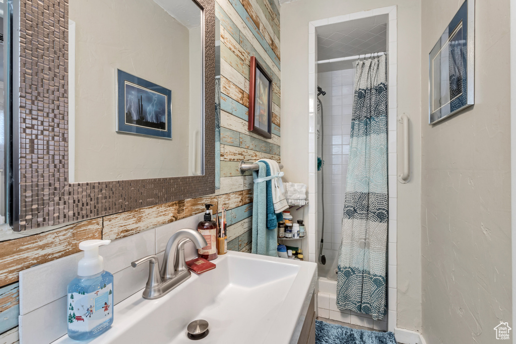 Bathroom with tasteful backsplash, tile walls, and vanity