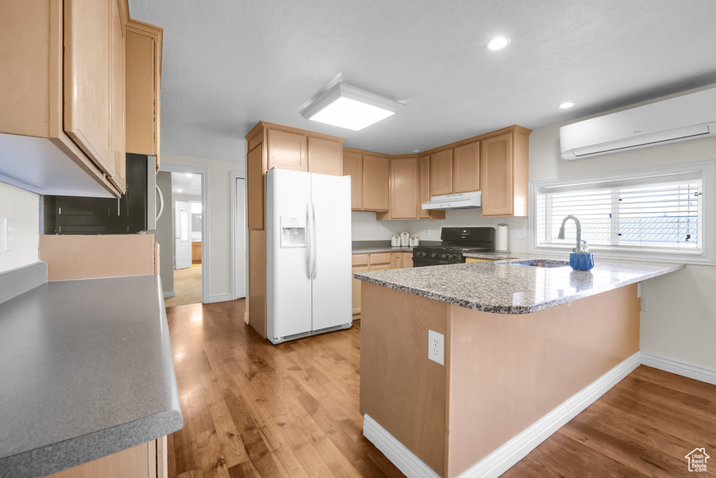 Kitchen with sink, light wood-type flooring, white fridge with ice dispenser, and range