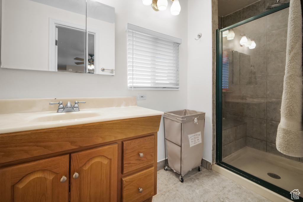 Bathroom featuring walk in shower, vanity, ceiling fan, and tile floors