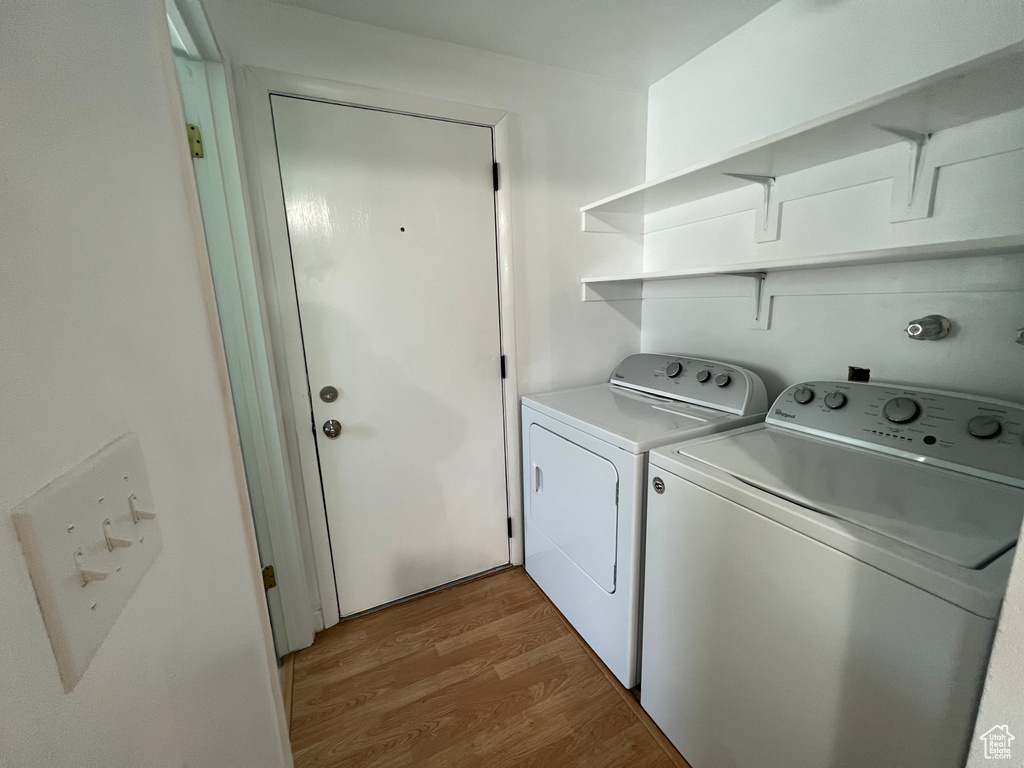 Laundry area with washing machine and clothes dryer and wood-type flooring
