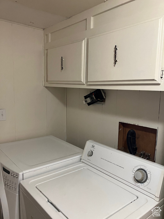 Clothes washing area featuring hookup for a washing machine, cabinets, and independent washer and dryer