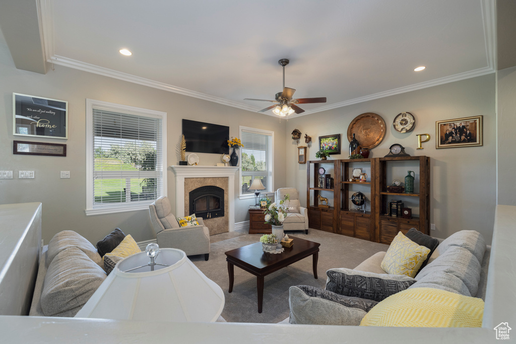 Living room featuring crown molding, light carpet, a wealth of natural light, and ceiling fan