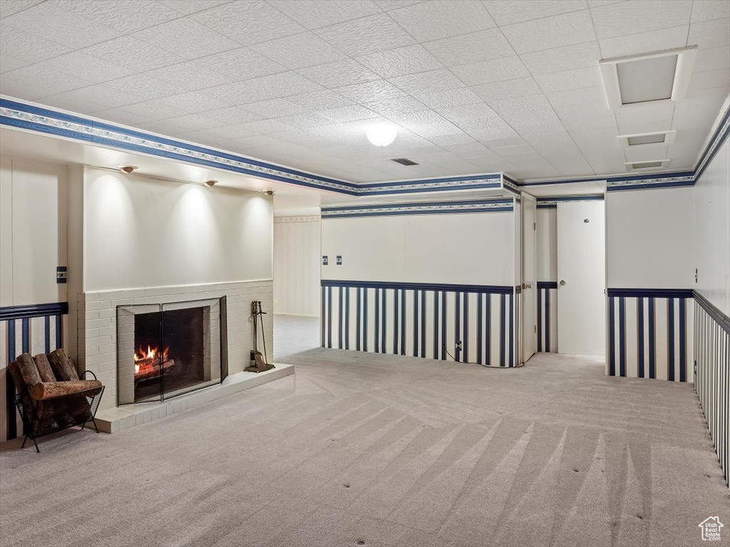 Basement with a fireplace and light carpet