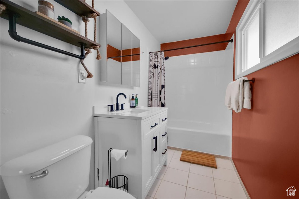 Full bathroom with vanity, toilet, shower / tub combo, and tile floors
