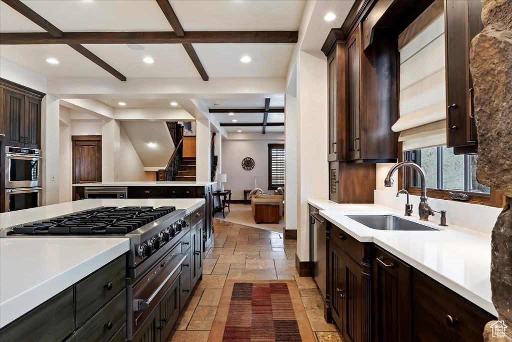 Kitchen with sink, stainless steel appliances, coffered ceiling, and light tile flooring