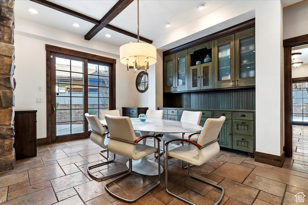 Dining space with dark tile flooring, a wealth of natural light, and coffered ceiling