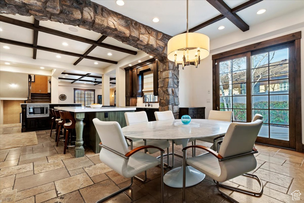 Tiled dining area featuring coffered ceiling, beamed ceiling, and a notable chandelier