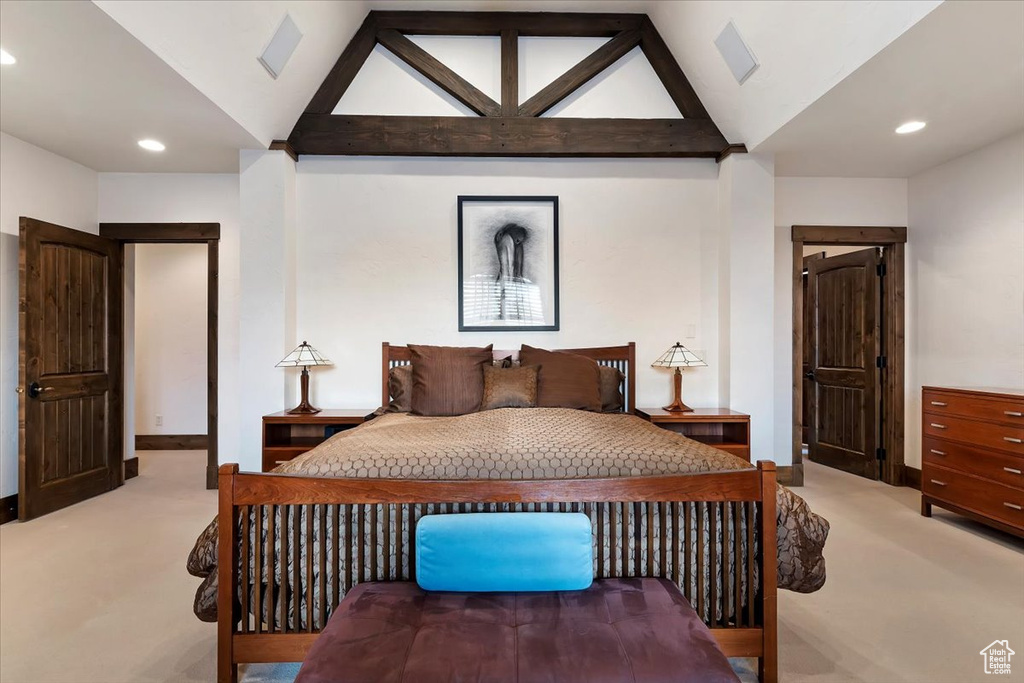 Bedroom featuring light carpet and vaulted ceiling with beams