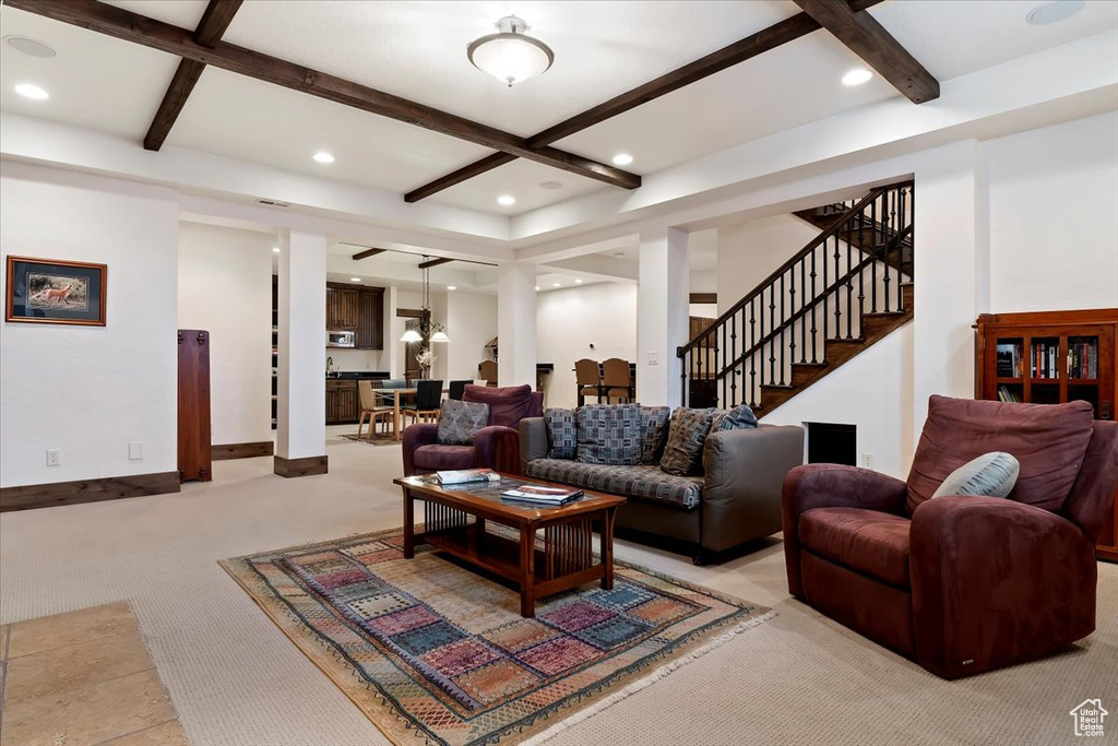 Living room featuring coffered ceiling, beamed ceiling, a notable chandelier, and light colored carpet