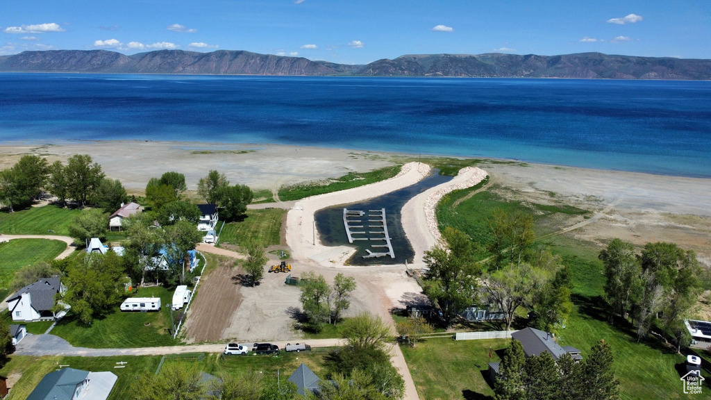 Drone / aerial view with a view of the beach and a water and mountain view