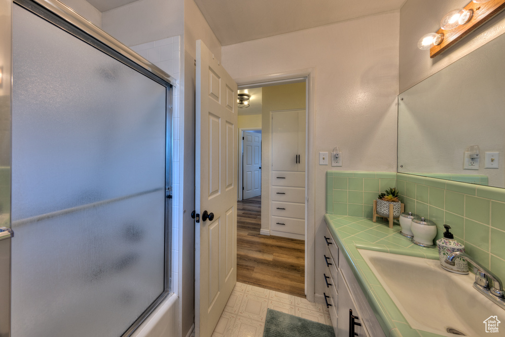 Bathroom featuring vanity, tasteful backsplash, and tile floors