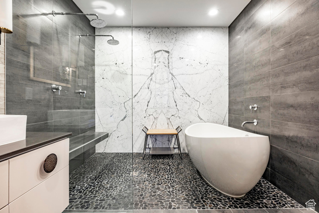 Bathroom with tile flooring, tile walls, and vanity