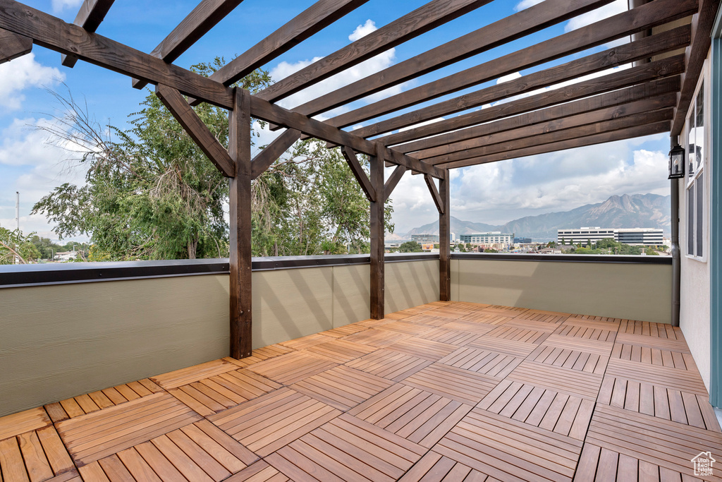 Wooden deck with a pergola and a mountain view