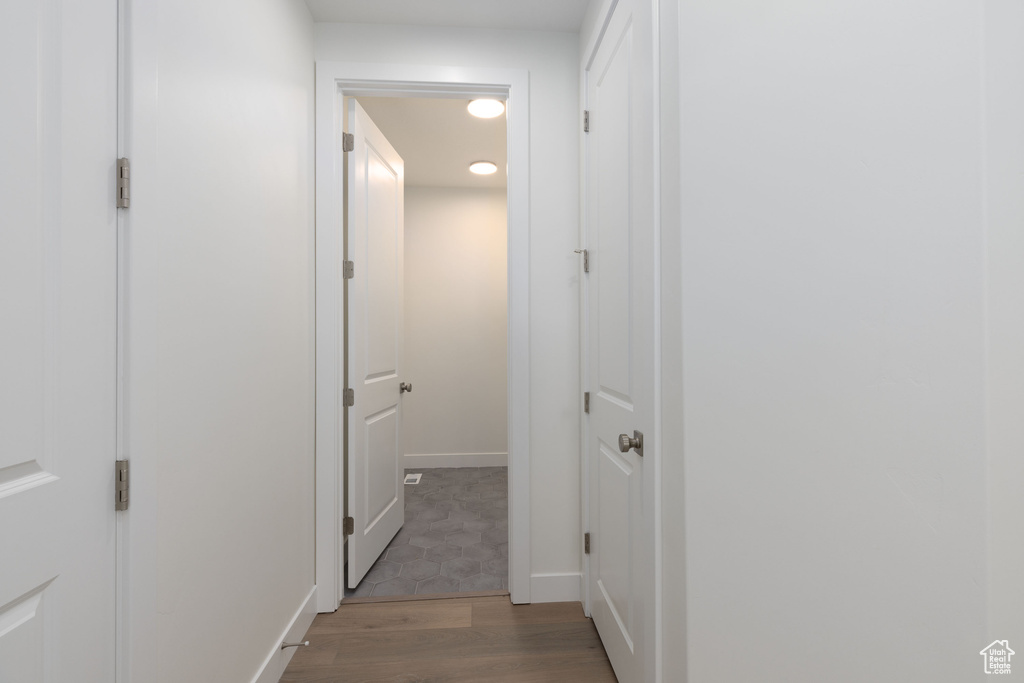 Corridor with hardwood / wood-style floors