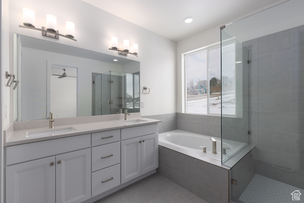 Bathroom featuring double vanity, shower with separate bathtub, tile flooring, and ceiling fan