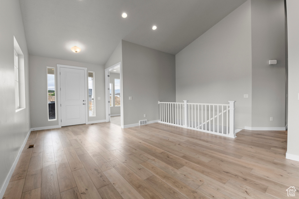Foyer featuring vaulted ceiling, a wealth of natural light, and light hardwood / wood-style floors