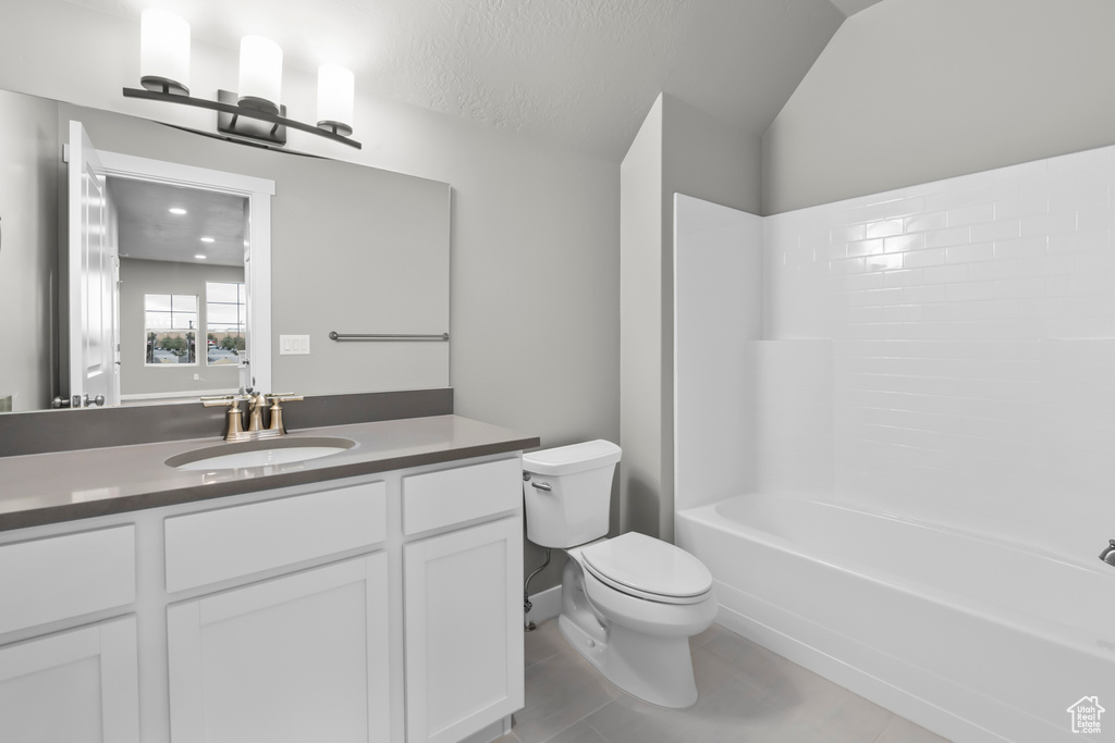 Full bathroom featuring vaulted ceiling, bathtub / shower combination, toilet, tile flooring, and vanity