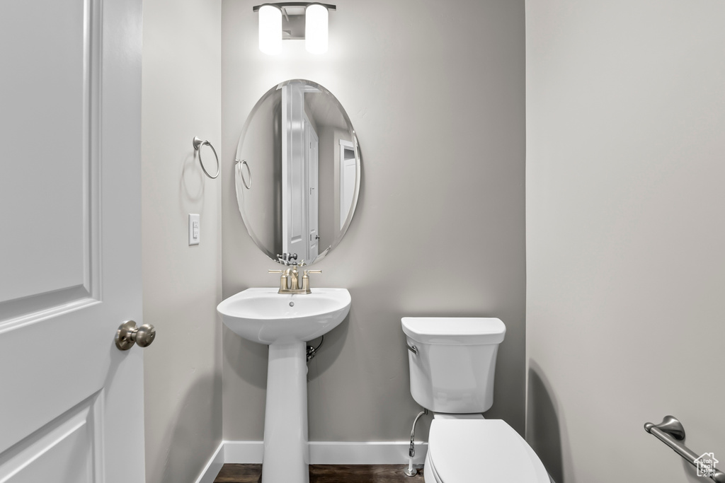 Bathroom featuring toilet, sink, and hardwood / wood-style floors