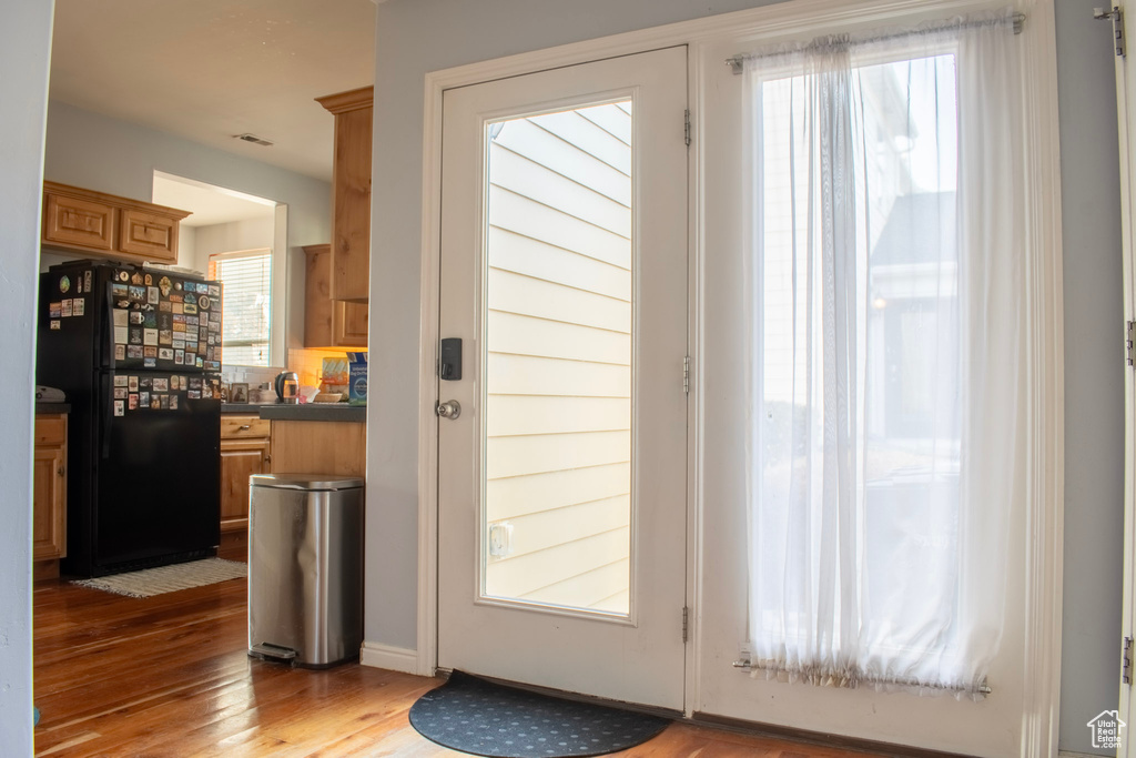 Doorway to outside with a wealth of natural light and light hardwood / wood-style floors