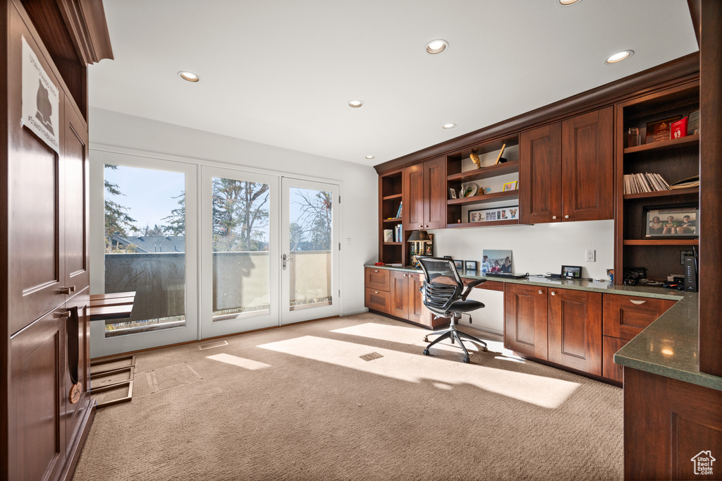 Office area with light colored carpet and built in desk