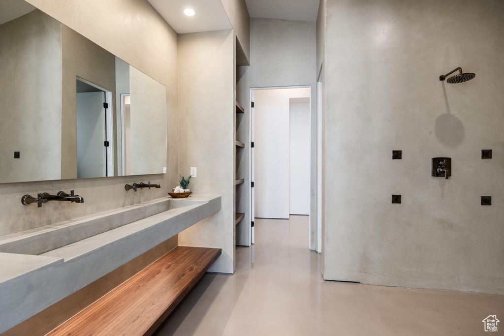 Bathroom featuring a high ceiling and concrete flooring