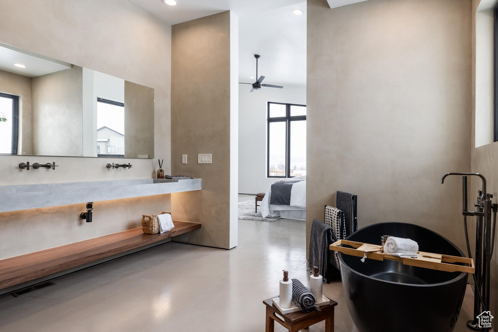 Bathroom featuring concrete floors, a towering ceiling, and ceiling fan