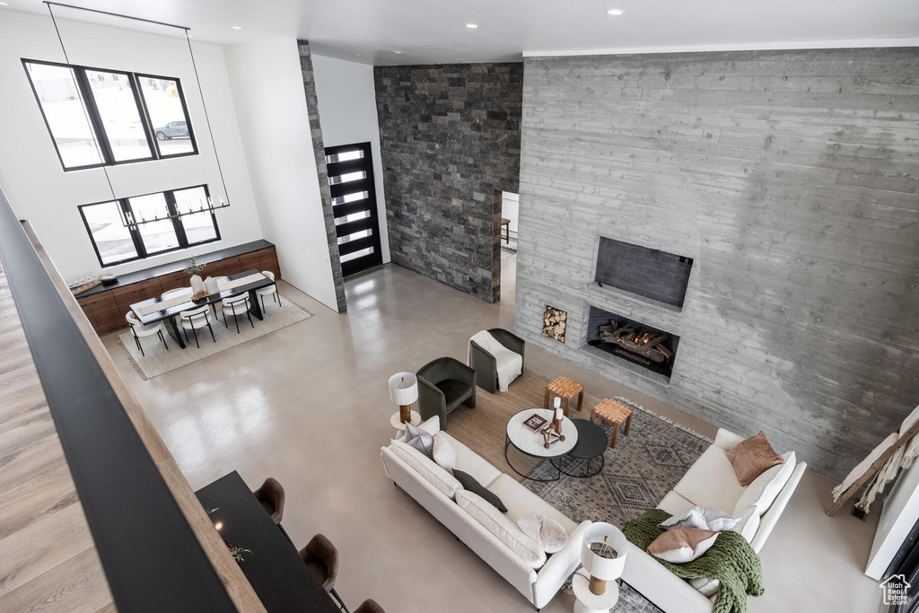 Unfurnished living room with a stone fireplace and a high ceiling