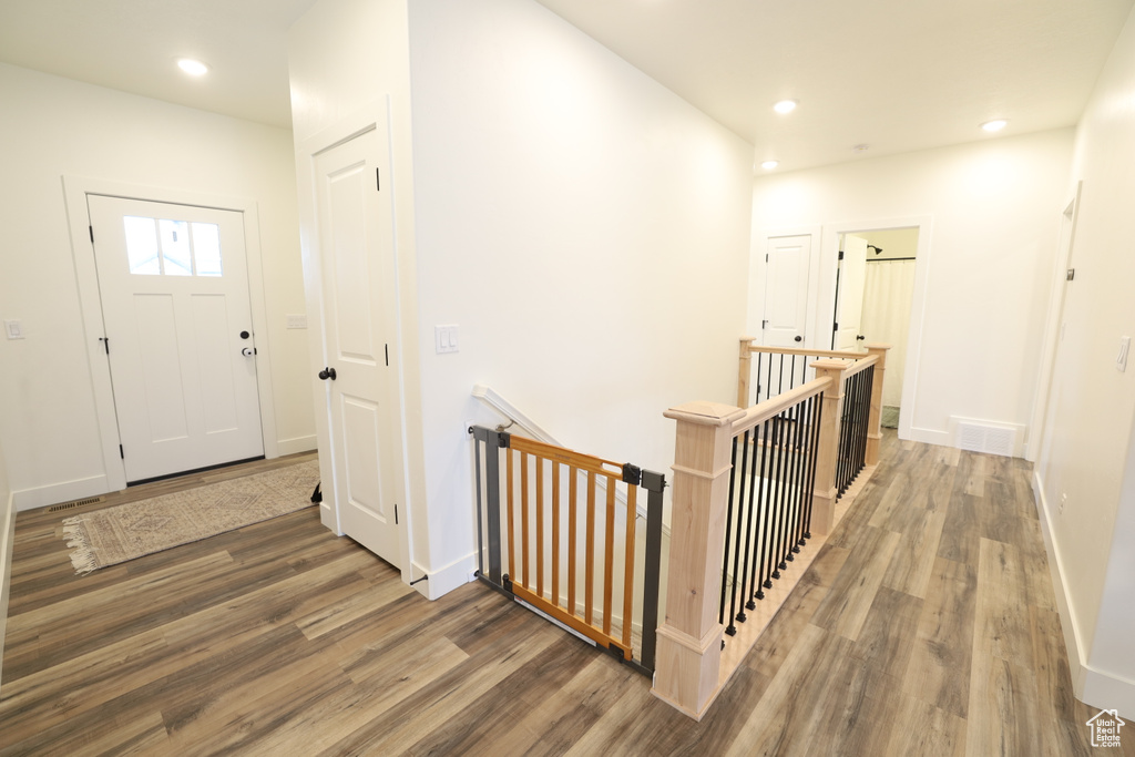 Hallway with hardwood / wood-style floors