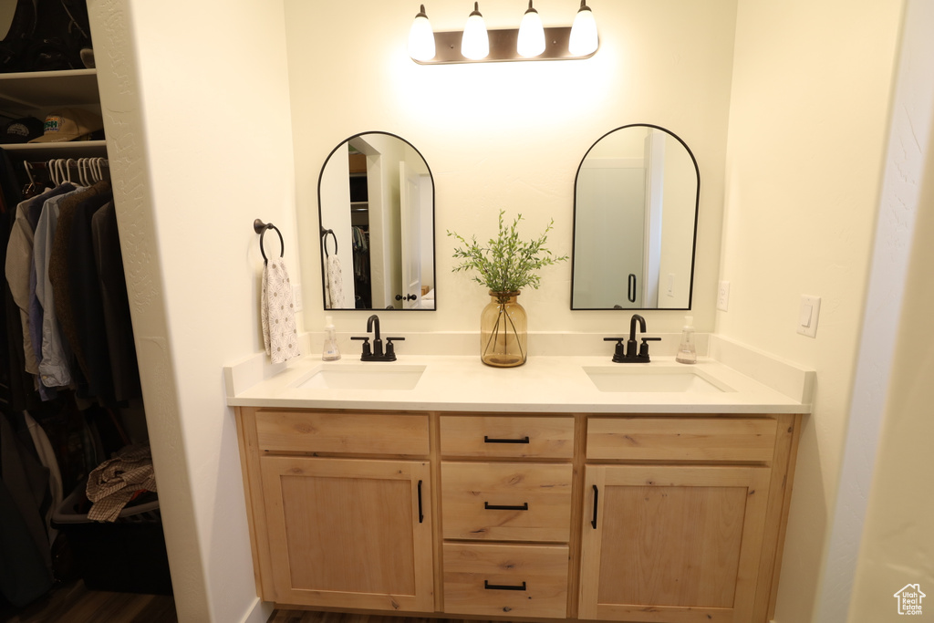 Bathroom featuring double vanity and wood-type flooring