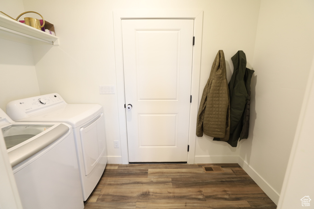 Laundry room featuring dark hardwood / wood-style flooring and washing machine and clothes dryer
