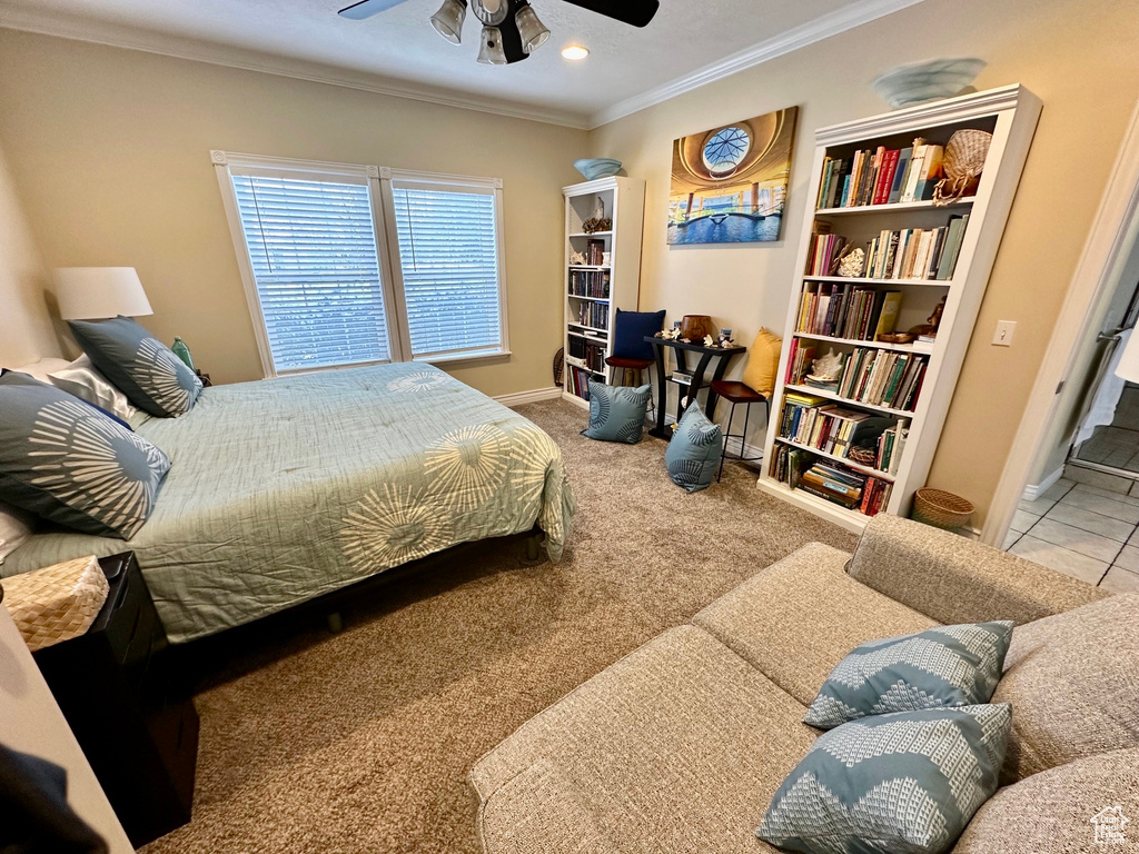 Bedroom featuring light carpet, ornamental molding, and ceiling fan