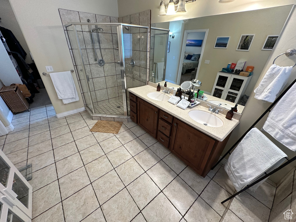 Bathroom featuring double vanity, tile flooring, and an enclosed shower