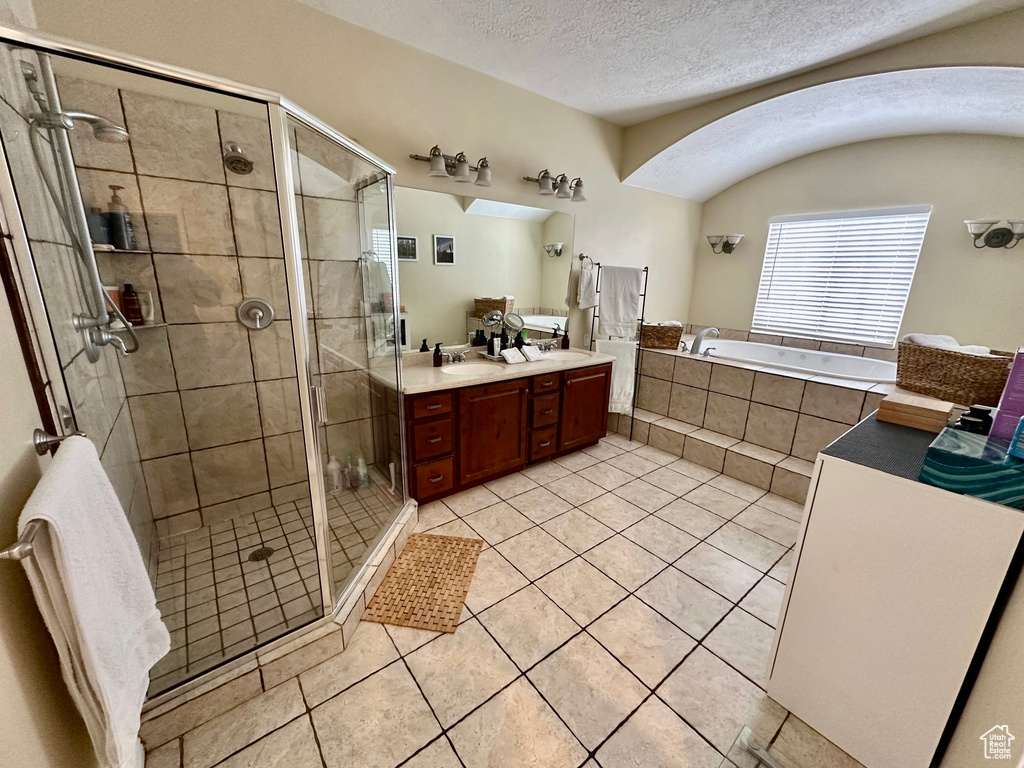 Bathroom featuring oversized vanity, a textured ceiling, and plus walk in shower