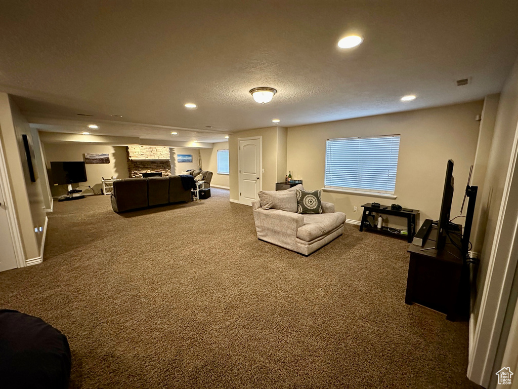 Carpeted living room with a textured ceiling and a fireplace