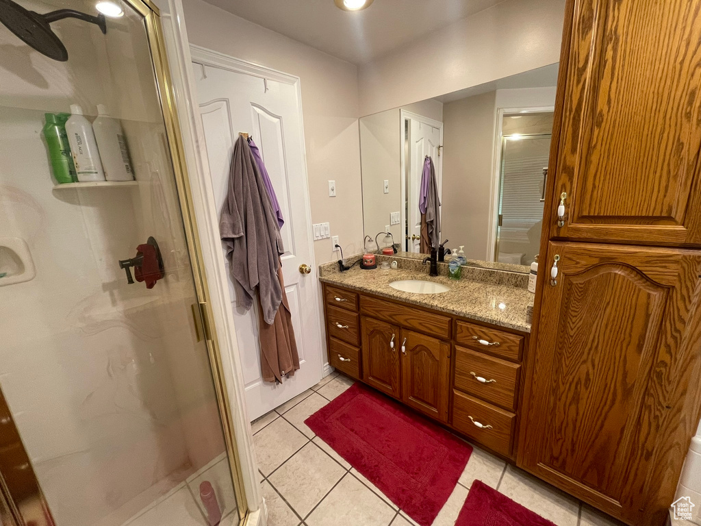Bathroom featuring an enclosed shower, large vanity, and tile floors