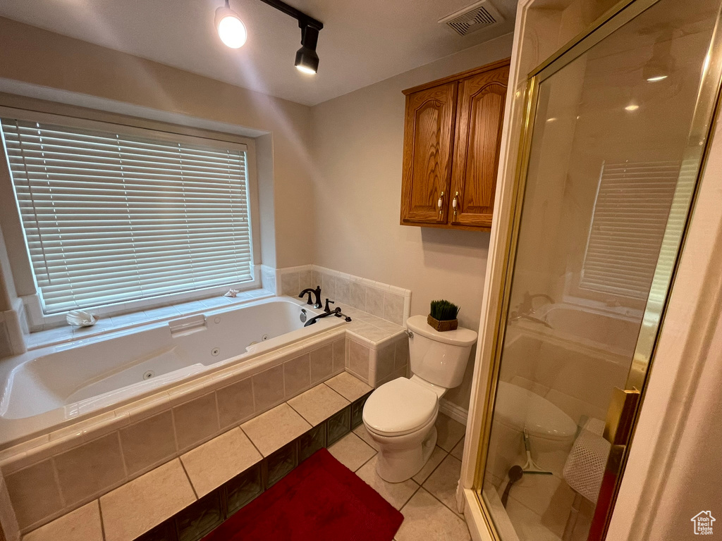 Bathroom with toilet, tile flooring, and plus walk in shower
