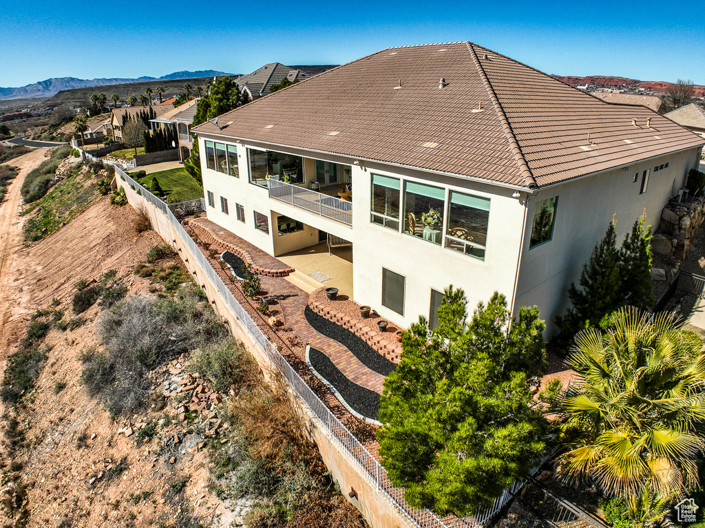 Back of house with a patio area and a mountain view