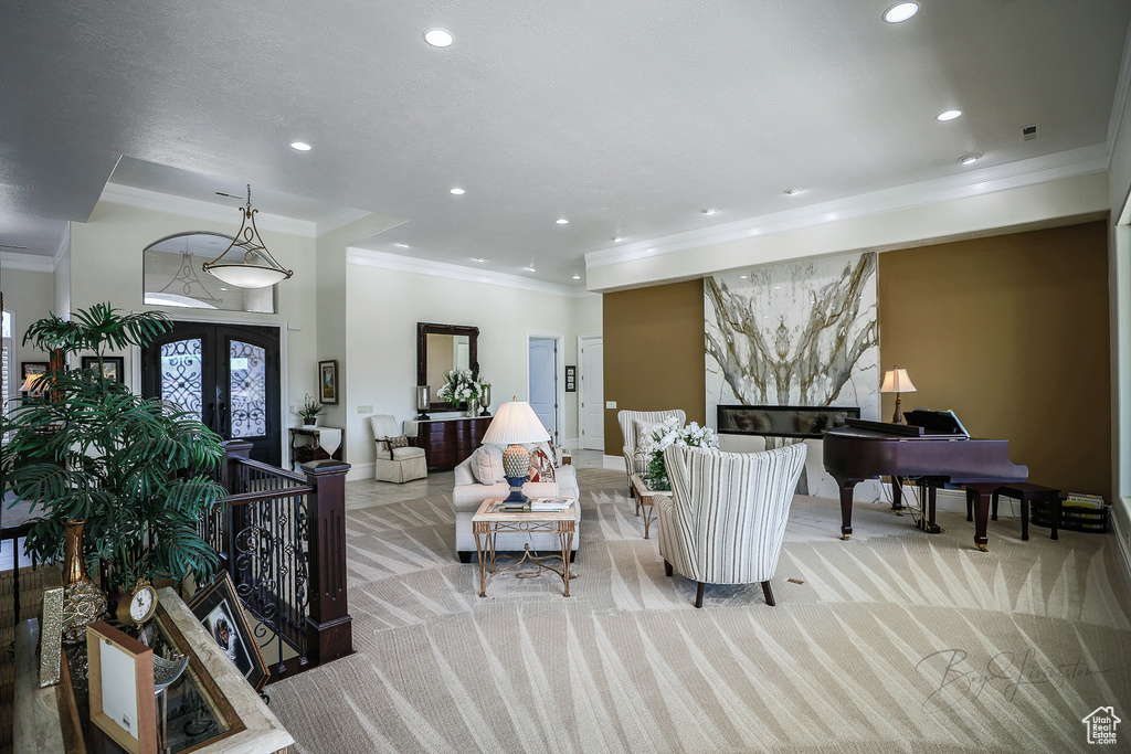 Carpeted living room featuring french doors and crown molding