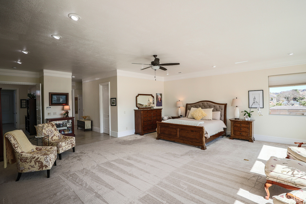 Bedroom featuring ornamental molding, light carpet, and ceiling fan