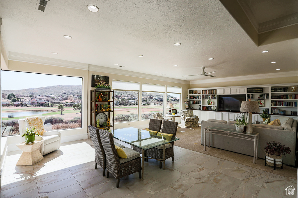Dining area with light tile flooring, a mountain view, a textured ceiling, and ceiling fan