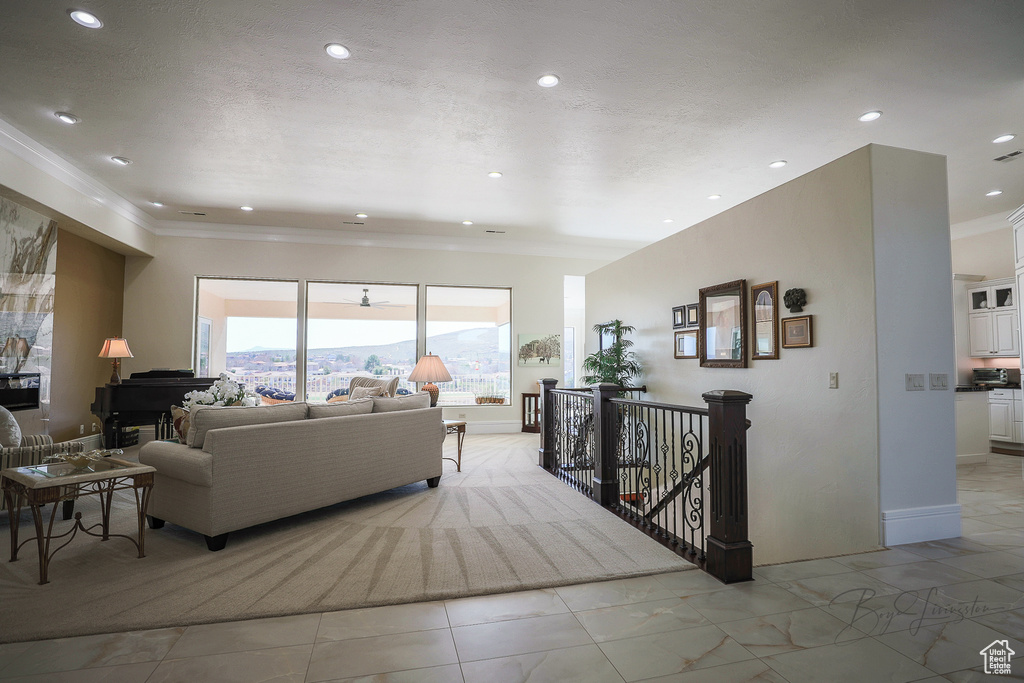 Living room featuring light tile floors and ornamental molding