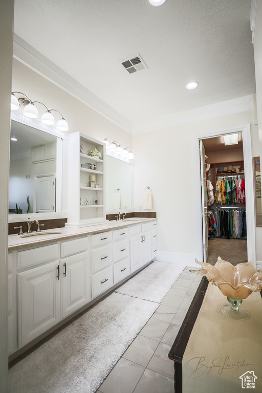 Bathroom featuring dual sinks, tile flooring, and large vanity