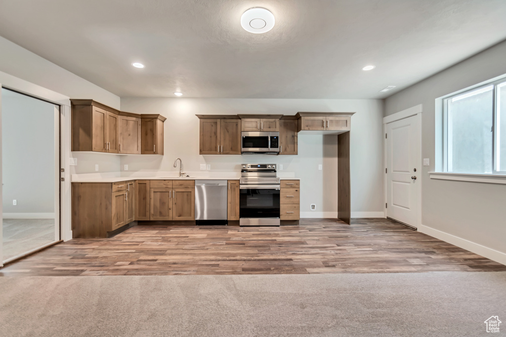 Kitchen featuring appliances with stainless steel finishes, sink, and light hardwood / wood-style floors