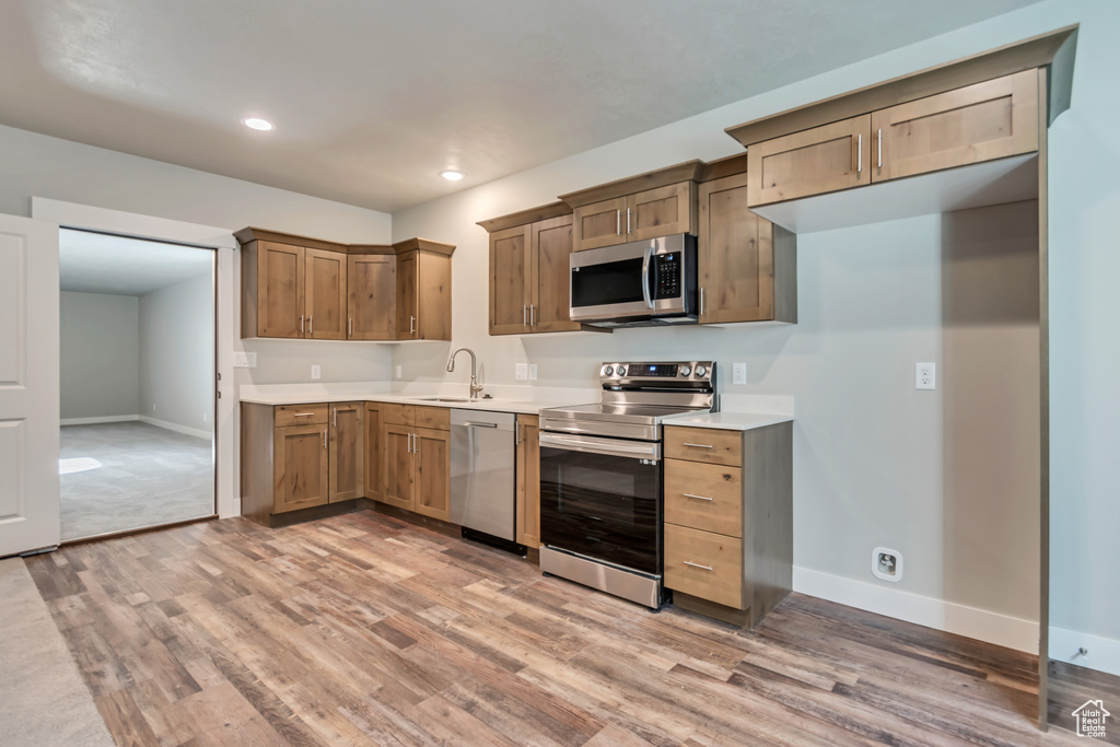 Kitchen featuring appliances with stainless steel finishes, sink, and hardwood / wood-style floors