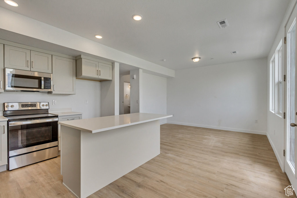 Kitchen featuring a center island, stainless steel appliances, and light hardwood / wood-style floors