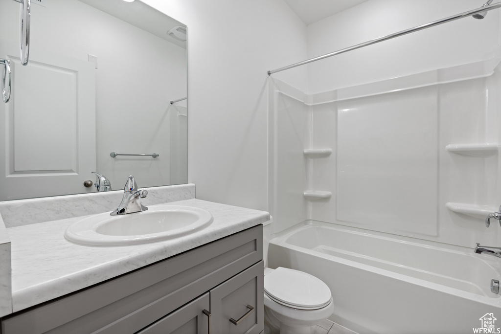 Full bathroom featuring vanity, toilet, tile floors, and shower / tub combination