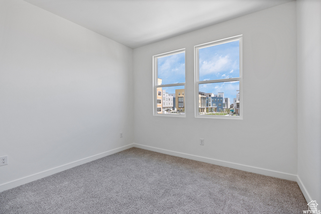 Unfurnished room with light carpet and a healthy amount of sunlight