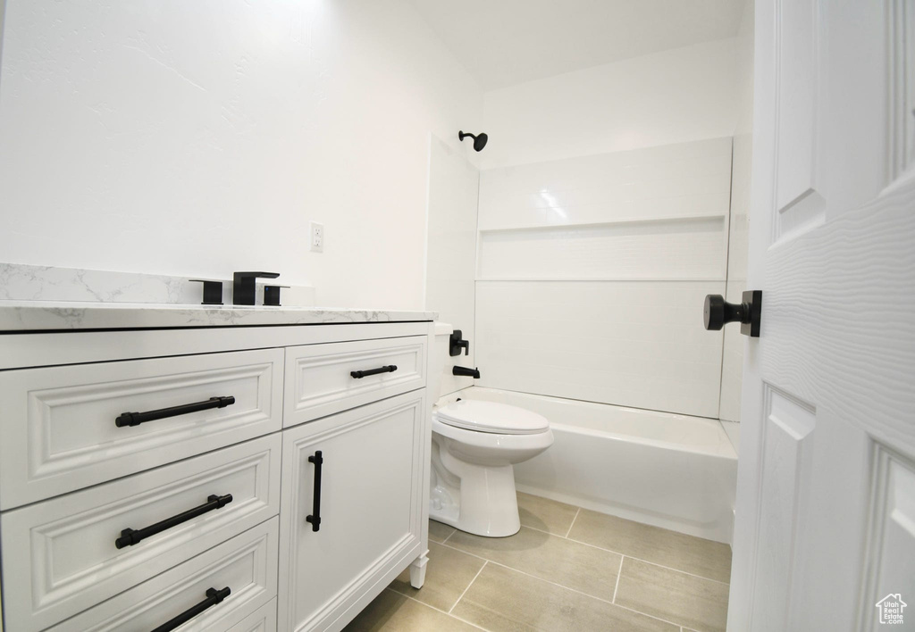 Full bathroom with shower / washtub combination, toilet, vanity, and tile flooring