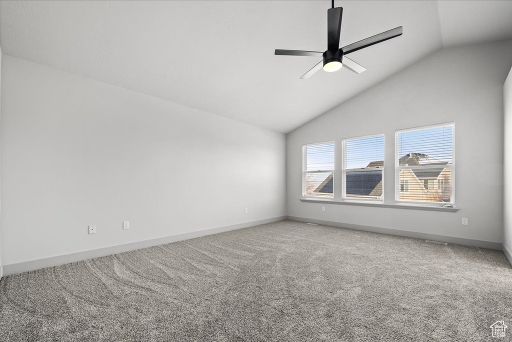 Unfurnished room featuring carpet floors, vaulted ceiling, and ceiling fan